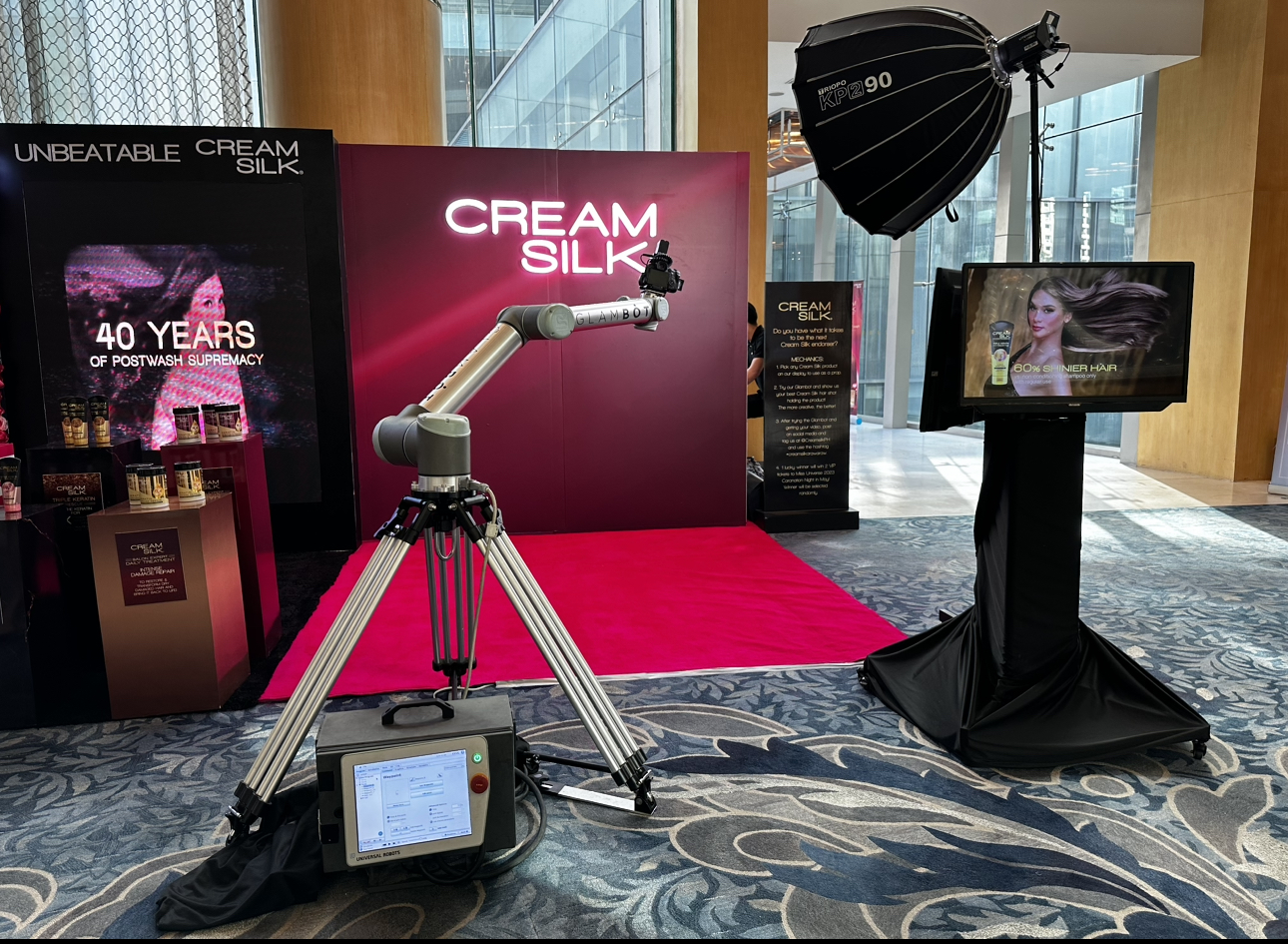 The GlamBot arm on a red carpet in front of the Cream Silk branded backdrop